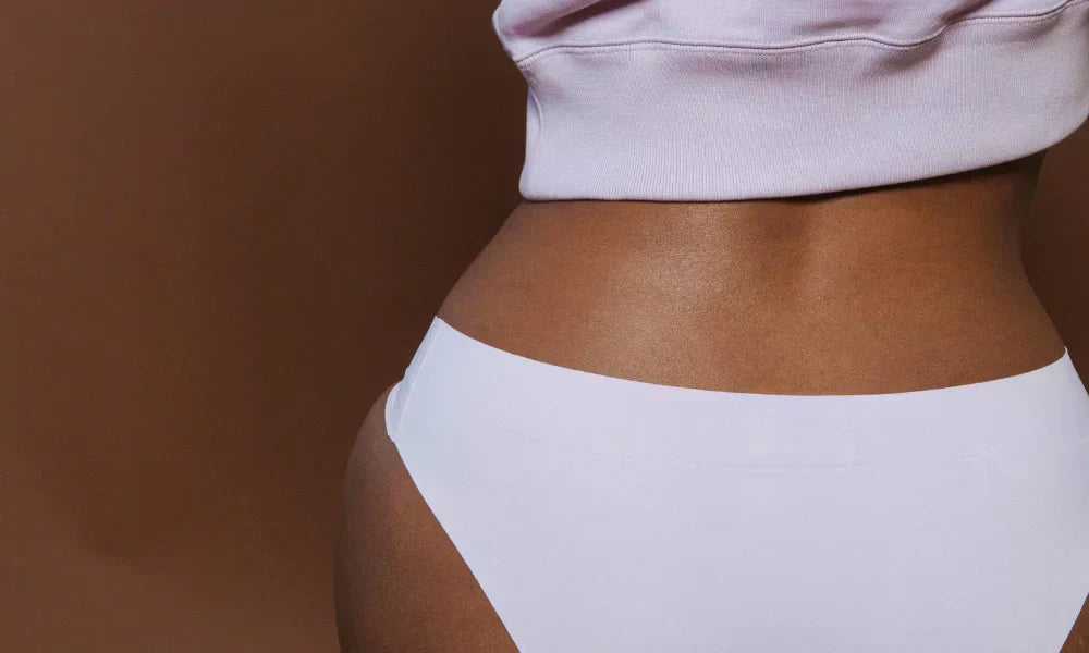 Nő bugyiban ül és pecsételő vérzést tapasztal