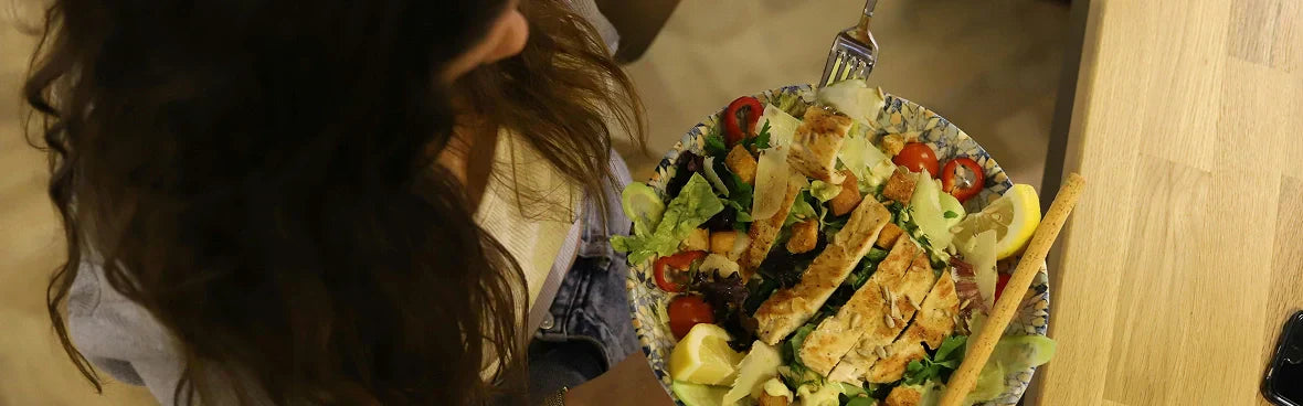 Egy nő egészséges csirkesalátát eszik a termékenysége érdekében